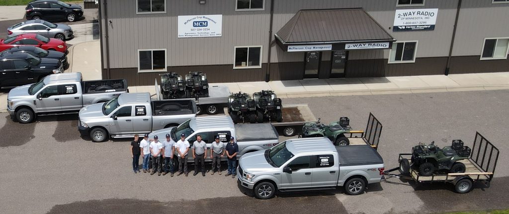 Picture of MCM employees with Trucks towing ATV on wagons